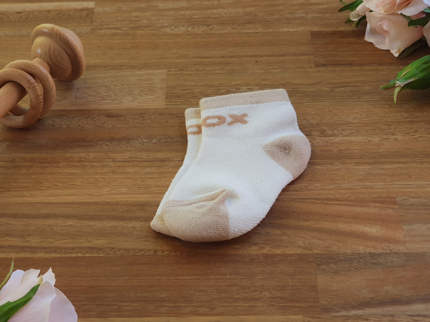 A pair of yellow baby ankle socks with tan accents and a partial tan logo reading 'FOX' on the side.