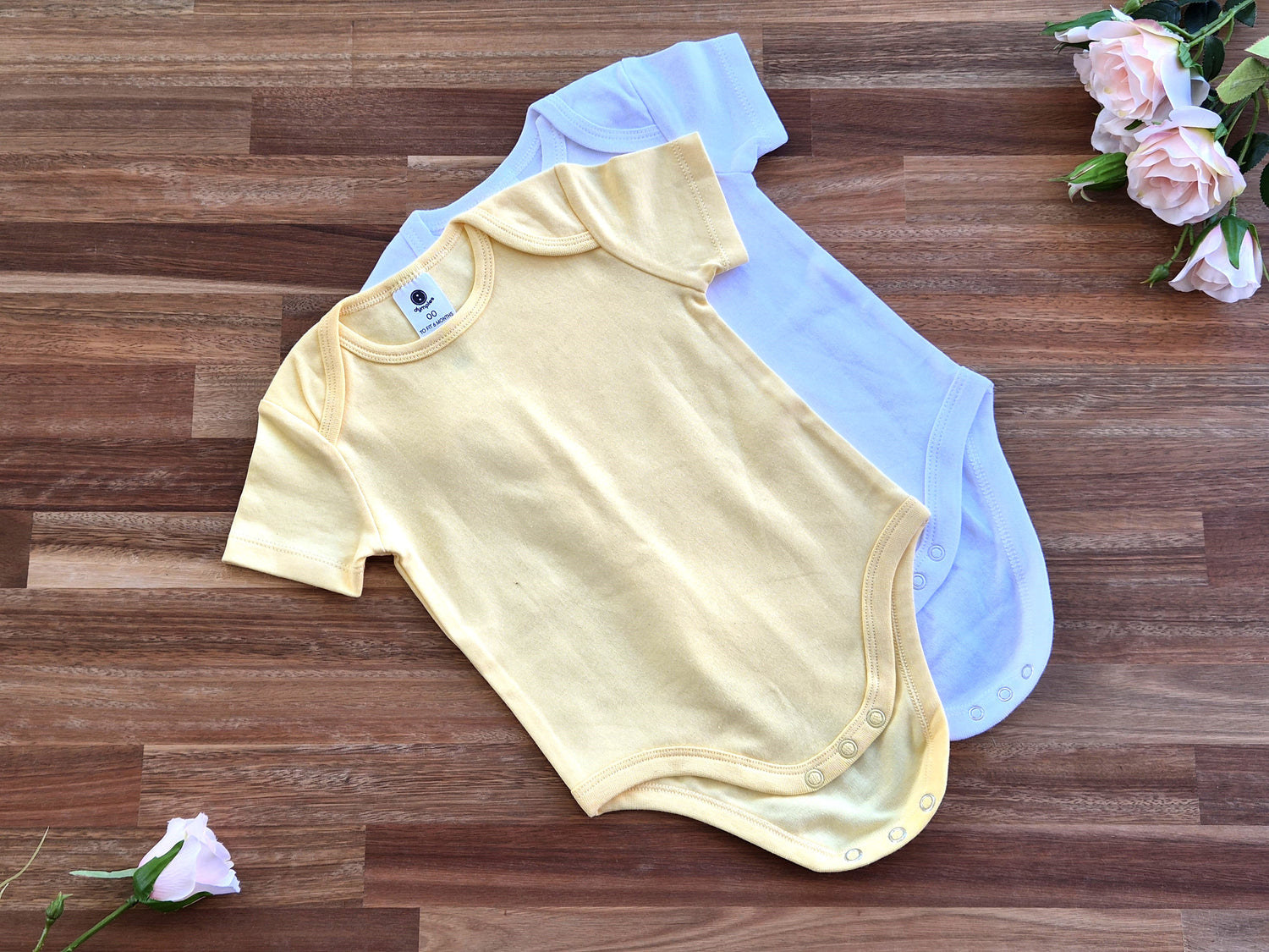 Two short-sleeve baby rompers in white and yellow  size 0.